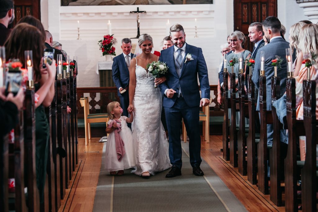 brudepar går ned af Kirkegulv mens de bliver fotograferet